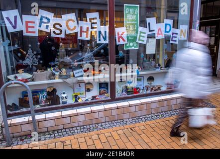 Schwerin, Germania. 05 gennaio 2021. Una donna passa davanti a un negozio nella città vecchia che è chiuso a causa della chiusura a Corona. Secondo la Northern Trade Association, la situazione del commercio al dettaglio nel Meclemburgo-Vorpommern sta diventando sempre più minacciosa nell'attuale secondo blocco. Credit: Jens Büttner/dpa-Zentralbild/dpa/Alamy Live News Foto Stock