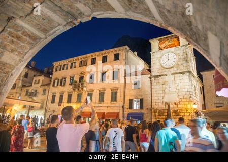 I turisti che visitano le navi da crociera si riuniscono di fronte alla Torre dell'Orologio, nella piazza principale della città vecchia, illuminata di notte. Foto Stock