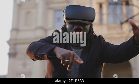 Un uomo entusiasta con il visore VR che esplora per la prima volta la realtà virtuale. Foto di alta qualità Foto Stock