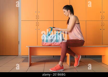 Donna con borsa sportiva in spogliatoio palestra Foto Stock