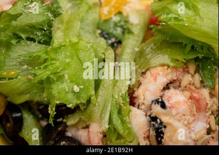 Insalata di verdure con gamberi e pinoli su un piatto. Cibo fatto in casa. Primo piano Foto Stock