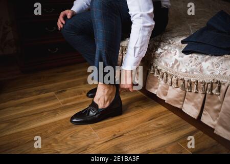 l'uomo indossa le scarpe al mattino in camera Foto Stock