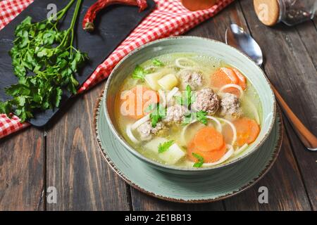 Zuppa di polpette e ingredienti su rustico tavolo di legno. Foto Stock