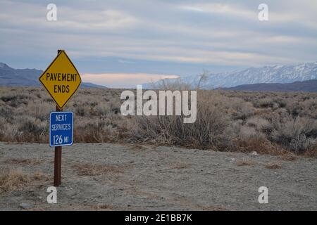 Segnale stradale per strada sterrata e prossimo servizio nella valle del lago di pesce vicino Big Pine California, Waucoba Road alla Valle della morte Foto Stock