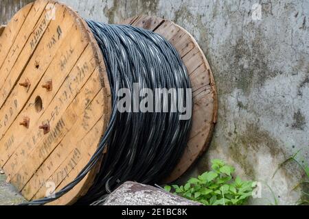 Un primo piano di un pesante rullo di cavi in testa per l'alimentazione elettrica utilizzata nelle reti elettriche. Foto Stock