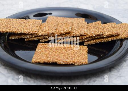 Fuoco selettivo primo piano di Til sakri o Tilgul un dolce indiano tradizionale popolare fatto di semi di Sesame e la gelificazione. Famoso festival Sankranti des Foto Stock