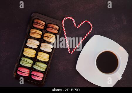 Festoso sfondo scuro. Cuore di dolci caramelle. Macaroni colorati. San Valentino. 14 di febbraio. Disposizione piatta, vista dall'alto. Idee regalo. Foto Stock