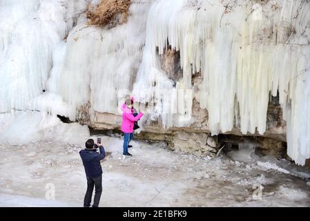 Mentougou, Mentougou, Cina. 6 gennaio 2021. Pechino, CINA-turisti scattare foto di fronte a una cascata di ghiaccio naturale a Guadaoyuan zona panoramica a Mentougou, Pechino, 3 gennaio 2021.con il recente calo precipitoso della temperatura, un gran numero di cascate di ghiaccio sono comparso in Mentougou zona montuosa.a ovest di Pechino, Tan Wang Road, Erba di melone area panoramica cascata naturale gruppo picco di ghiaccio appeso capovolto, cristallo chiaro, puro ghiaccio bianco appeso sulla scogliera enorme, costituiscono un bellissimo paesaggio invernale, è diventato l'ovest di Pechino turismo invernale web celebrity card in recente Foto Stock