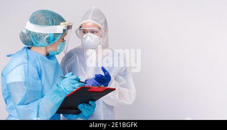 Banner. Due medici discutono l'elenco dei pazienti ammessi per la vaccinazione medica in pandemia su sfondo grigio. Spazio laterale. Foto Stock