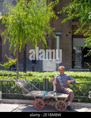 TEHERAN, IRAN - 22 MAGGIO 2017: Uomo seduto su un carrello vuoto per la strada di Teheran. Il tasso di disoccupazione iraniano sarà del 16% nel dicembre 2020, come riportato da Inte Foto Stock