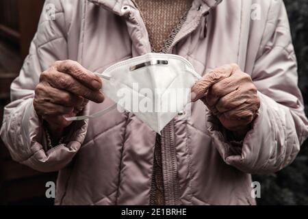 primo piano di donne più anziane che tengono la maschera facciale Foto Stock