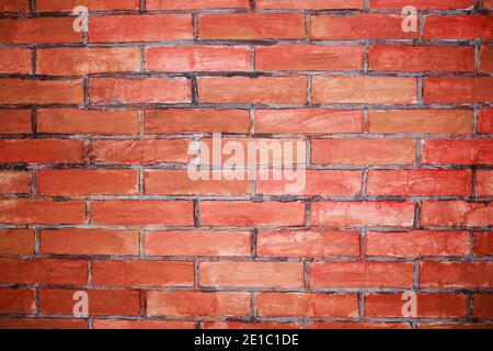Vecchio muro di mattoni colorato con agenti atmosferici con crepe e graffi. Muratura Foto Stock