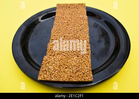 Fuoco selettivo primo piano di Til sakri o Tilgul un dolce indiano tradizionale popolare fatto di semi di Sesame e la gelificazione. Famoso festival Sankranti des Foto Stock