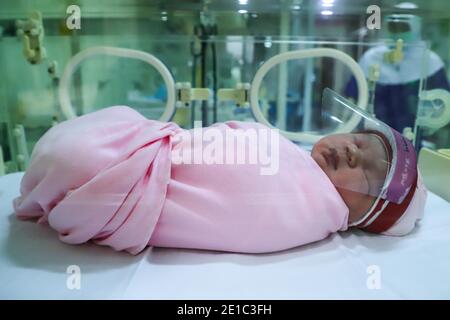 Pechino, Cina. 6 gennaio 2021. Un neonato indonesiano indossa uno scudo facciale come protezione contro COVID-19 presso l'ospedale di maternità Tambak di Giacarta, Indonesia, il 17 aprile 2020. Credit: Xinhua/Alamy Live News Foto Stock