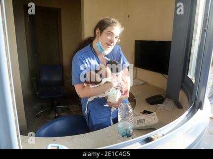 Pechino, Libano. 4 agosto 2020. Un'infermiera si prende cura di tre bambini in un ospedale danneggiato dopo l'esplosione a Beirut, Libano, 4 agosto 2020. Credit: Bilal Jawich/Xinhua/Alamy Live News Foto Stock