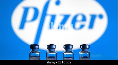 Mosca - 5 gennaio 2021: Vaccino Pfizer COVID-19, flaconi medici con vaccino US per il coronavirus su sfondo logo. Concetto di farmaco virus corona, non corroso Foto Stock