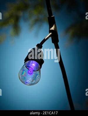 Una luce viola su un patio esterno del ristorante. Foto Stock