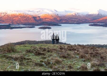 Loch Lomond - escursionisti che godono di una vista invernale dell'alba da Conic Hill, Scozia, Regno Unito Foto Stock