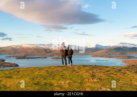 Loch Lomond - escursionisti che godono di una vista invernale dell'alba da Conic Hill, Scozia, Regno Unito Foto Stock