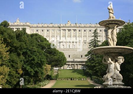 I visitatori e i turisti camminano nei Giardini Jardines de Sabatini con la facciata nord del Palazzo reale di Madrid. Foto Stock