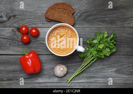 Il gazpacho fresco in una ciotola e mollica di pane, prezzemolo, pepe, aglio. Vista superiore Foto Stock