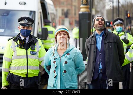 Londra, Regno Unito. - 6 gennaio 2021: I manifestanti anti anti anti-blocco sono arrestati mentre presenziano ad una protesta in Piazza del Parlamento contro ulteriori misure di pandemia da coronavirus del governo. Foto Stock