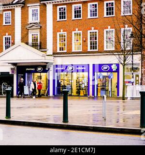 Londra UK, gennaio 06 2021, gli acquirenti o le persone che camminano oltre UN negozio di farmacia Boots in UN giorno di Wet Winters Foto Stock