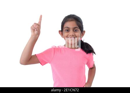 Ritratto di una bella e intelligente ragazza indiana mostrando e puntando il numero uno con indice dito mentre sorridendo fiducioso e felice. Foto Stock