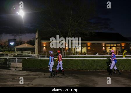 Una veduta generale mentre i jokey si dirono verso l'anello della parata all'Ippodromo di Kempton Park. Foto Stock