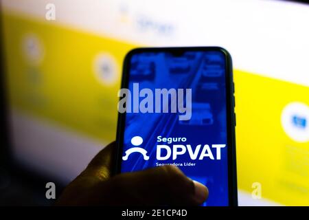 Brasil, 06/01/2020 - Detran / Veículos - Aplicativo do sistema de DPPAT nacional exibido em tela de smartphone e carnê de pagamento do IPVA 2021. (Punto Foto Stock