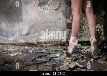 Closeup di piedi ballerina su punta in scarpe da ballo in un luogo abbandonato Foto Stock