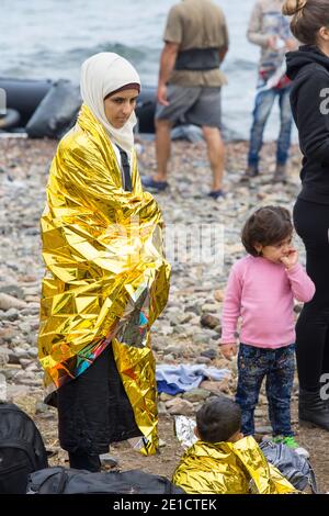 I migranti siriani in fuga dalla guerra e in fuga in Europa, atterrando sull'isola greca di Lesvos sulla costa settentrionale a EFTHALOU e aiutati a terra da volu Foto Stock