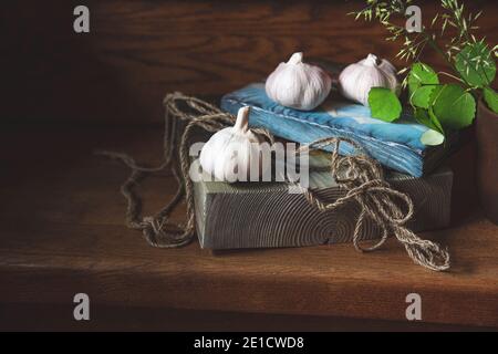 Bella vita morta su una scala di legno, pittura. Aglio, corda di iuta su tavole di legno, ramo di betulla in un vetro di argilla. Foto Stock