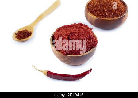 Pasta di pepe di stile turco (biber salcasi). Ciotola di legno con salsa rossa e peperoncino fresco isolato su bianco. Foto Stock