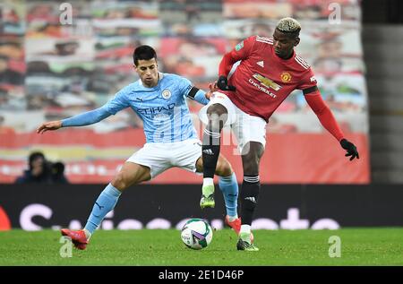 Joao Cancelo di Manchester City (a sinistra) e Paul Poggiba di Manchester United combattono per la palla durante la partita semi-finale della Carabao Cup a Old Trafford, Manchester. Foto Stock