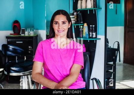 Donna latina che possiede la sua attività di taglio dei capelli a Città del Messico Foto Stock