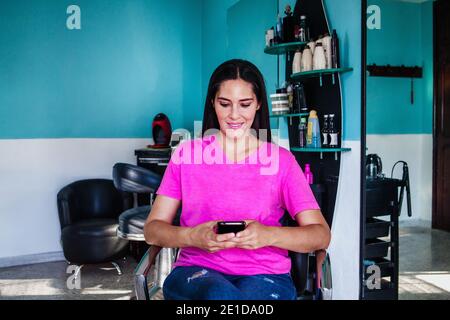 Donna latina che possiede la sua attività di taglio dei capelli a Città del Messico Foto Stock