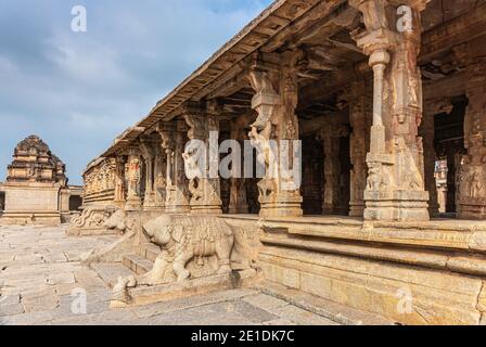 Hampi, Karnataka, India - 5 novembre 2013: Tempio Sri Krishna in rovina. Pietra marrone scolpito intensivamente colonne e balaustre lungo mandapam Foto Stock