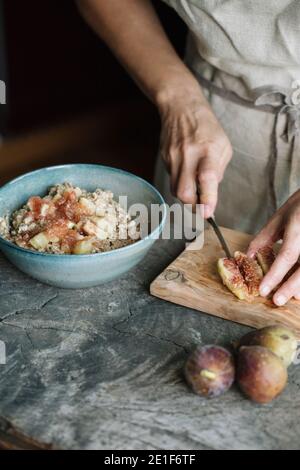 Donna che taglia fichi freschi su tagliere Foto Stock