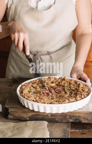 Donna che taglia in casa fichi torta Foto Stock