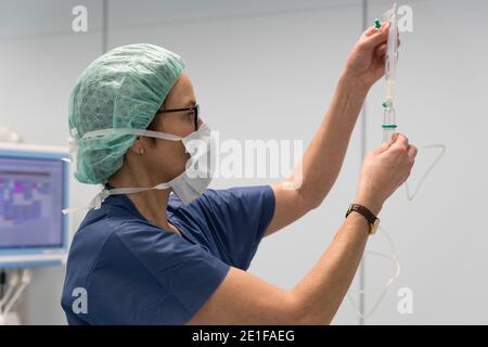 un anestesista prepara un'infusione nella sala operatoria Foto Stock