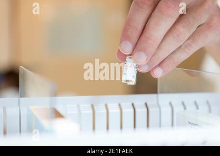 mano di un operatore sanitario che prende una fiala di medicinale Foto Stock