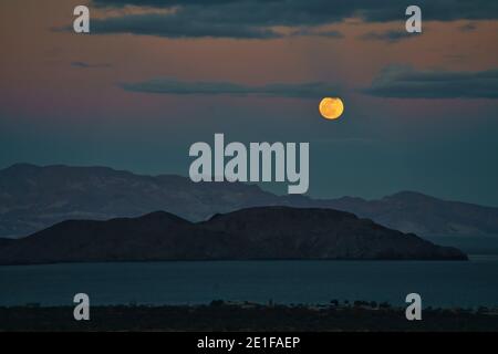 la luna piena sorge nel deserto sopra una baia dentro baja california Foto Stock