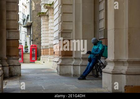 Londra, Regno Unito. 06 gennaio 2021. Deliveroo corriere in attesa della prossima consegna online order.England terzo blocco nazionale entra legalmente in vigore. Credit: SOPA Images Limited/Alamy Live News Foto Stock