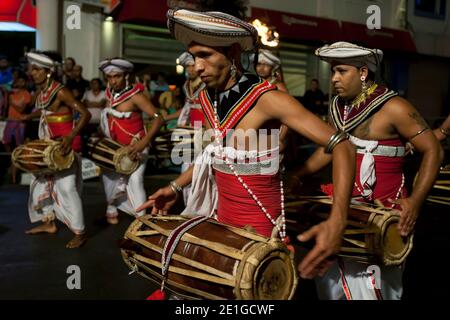 I giocatori di Gatabera hanno battuto la batteria mentre si esibiscono lungo una strada a Kandy, Sri Lanka, durante la buddista Esala Perahera (grande processione). Foto Stock