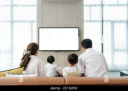 Asian felice famiglia seduta e guardando la televisione in soggiorno a casa e passato tempo di qualità insieme per attività in vacanza giorno, vacanza, happi Foto Stock