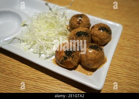 Primo piano Takoyaki, spuntino giapponese a forma di palla fatto di farina di grano e polpo a dadini Foto Stock