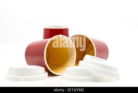 Tazze da caffè da asporto usate con macchie di caffè sul terreno, primo piano tazze da caffè da asporto usate su sfondo bianco, vista ad angolo basso vicino al terreno. Foto Stock