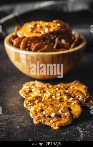 Mini pretzel piatti salati su tavolo nero. Foto Stock