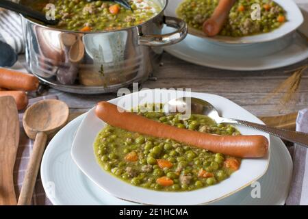 Zuppa di piselli con hot dog su un tavolo da cucina Foto Stock